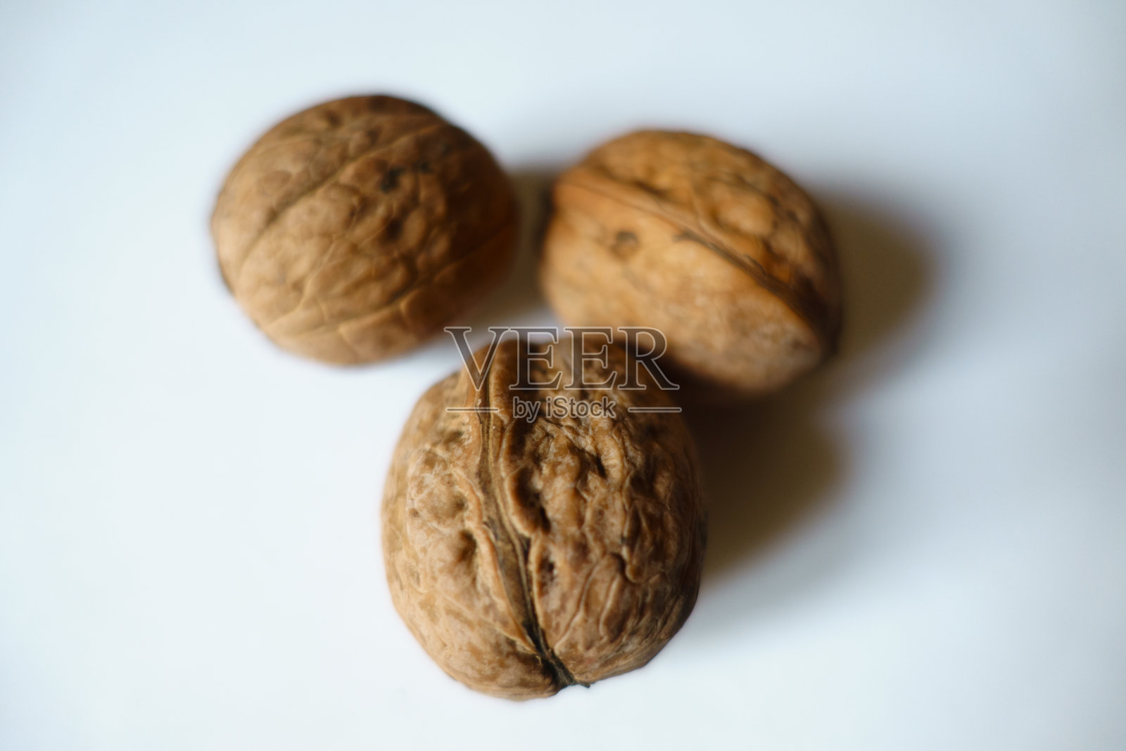 三个成熟的棕色无壳波斯核桃果实的近景照片摄影图片