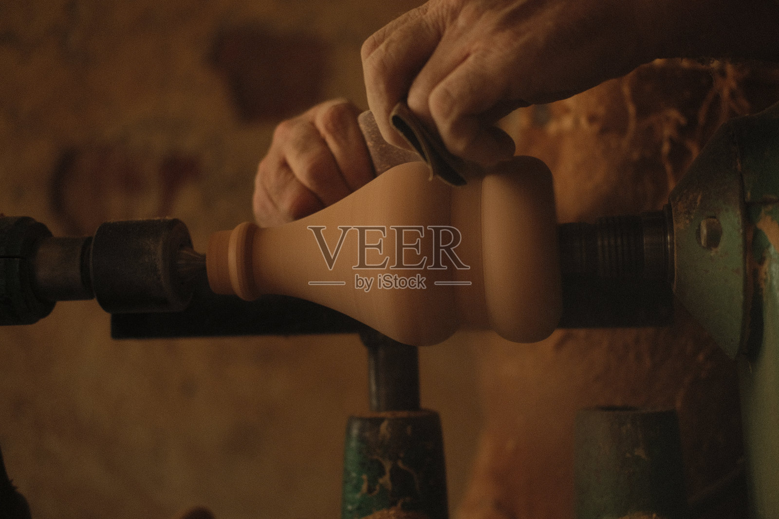 一个木匠在车床上转动木头的特写。照片摄影图片