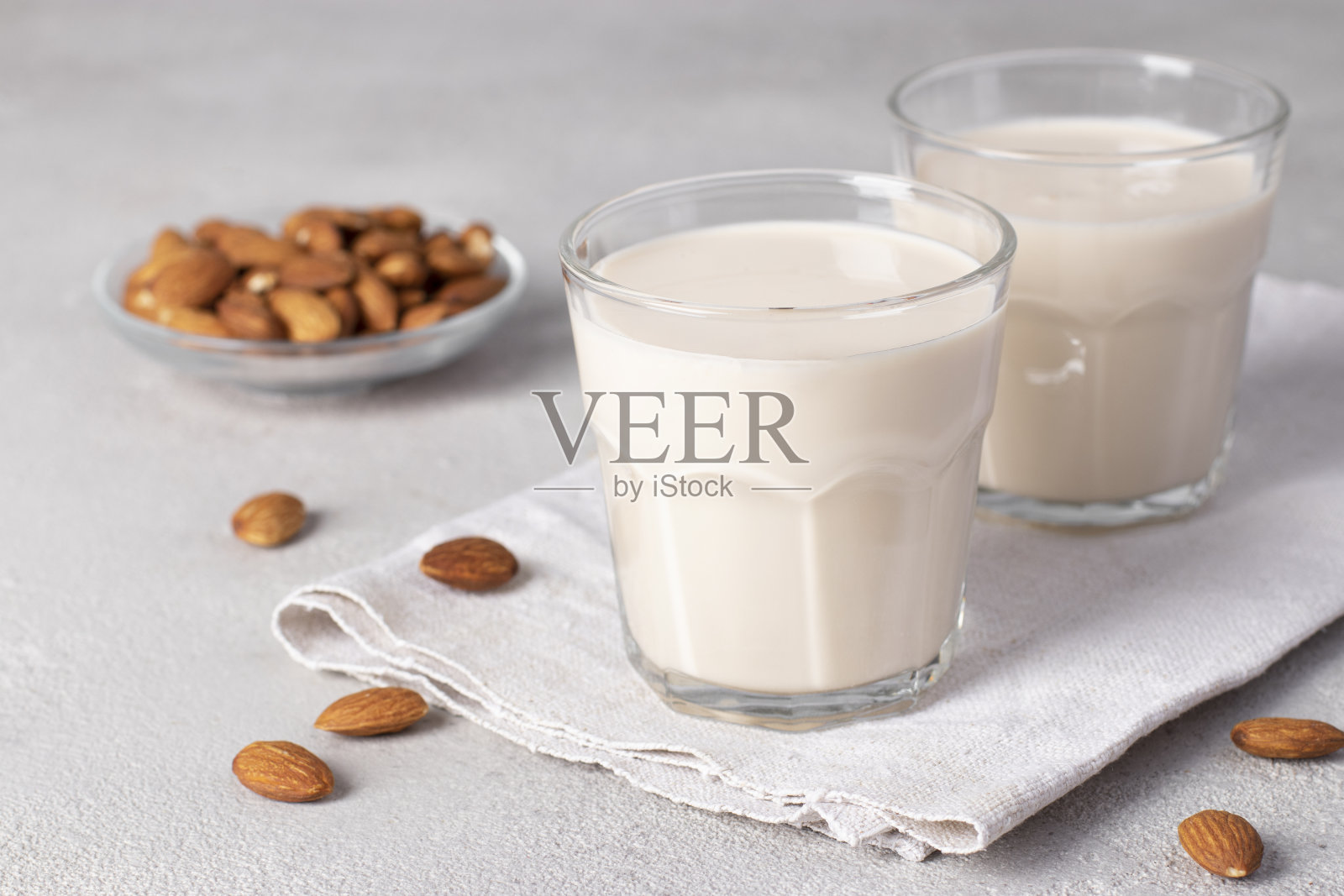 浅灰色桌上两杯新鲜杏仁奶，健康素代奶照片摄影图片