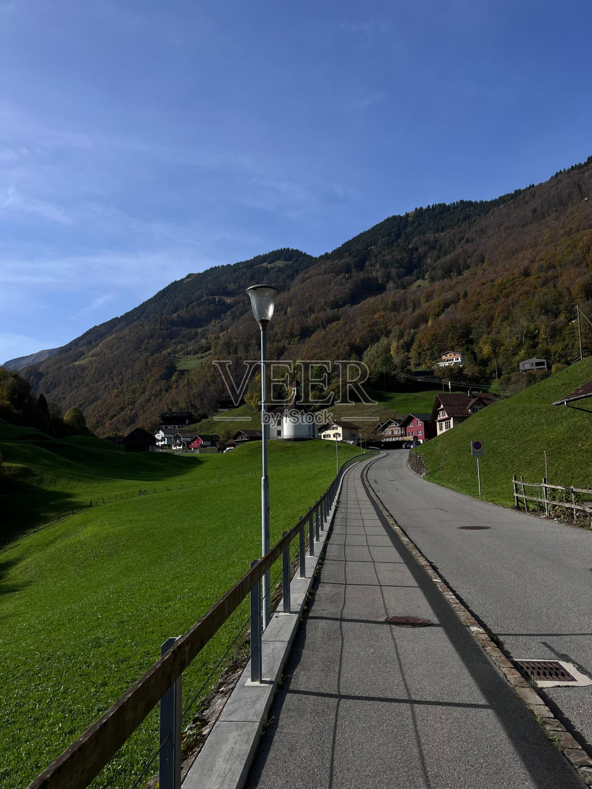 一条通往靠近山区建筑的小路的垂直镜头照片摄影图片