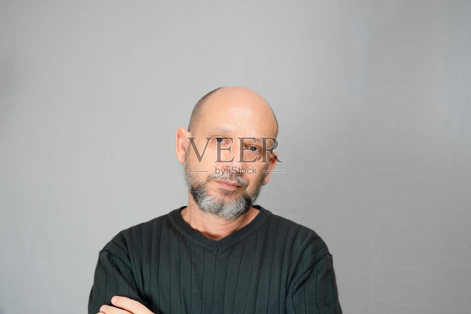 一个成熟的男人站在白色背景上的肖像。严肃的大胡子男人照片摄影图片