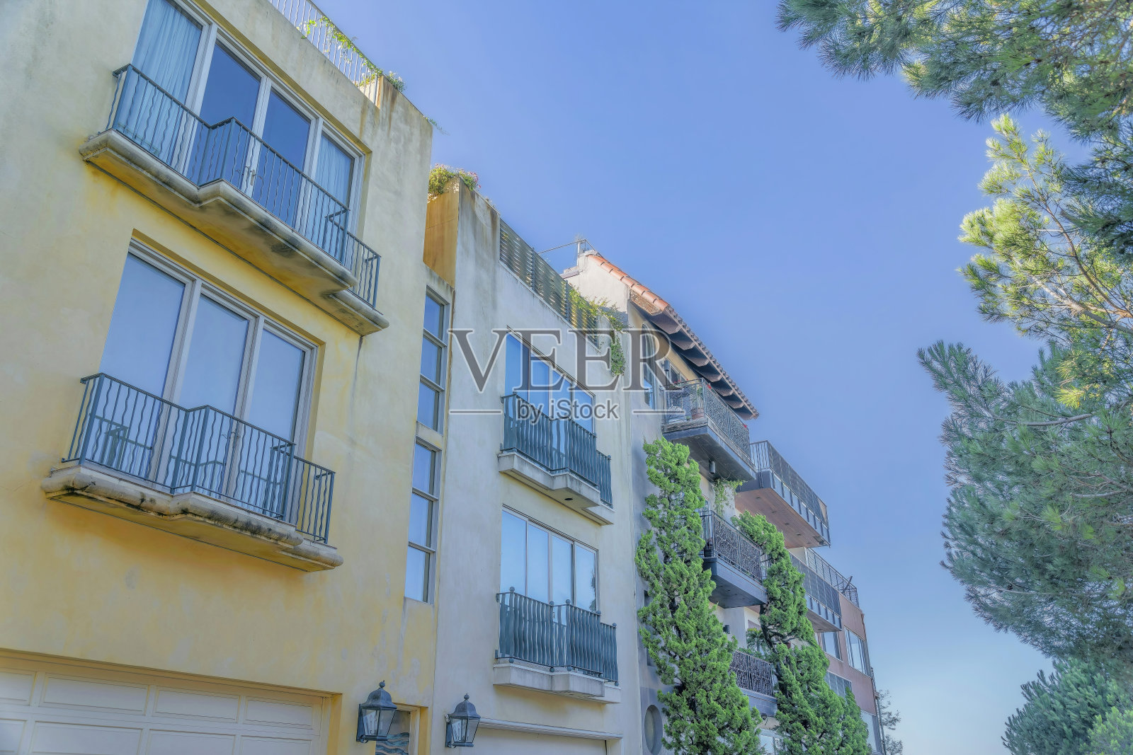 在阳光明媚的日子里，小阳台对着蓝天的住宅外观照片摄影图片