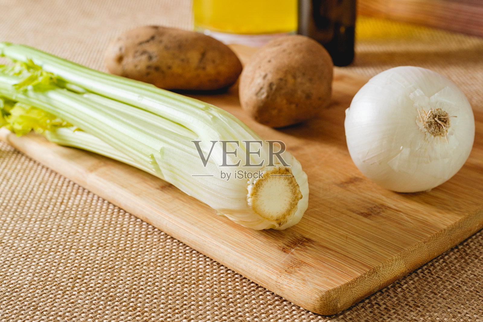 在乡村背景上木制砧板上的生蔬菜的素食套装。芹菜汤的配料照片摄影图片