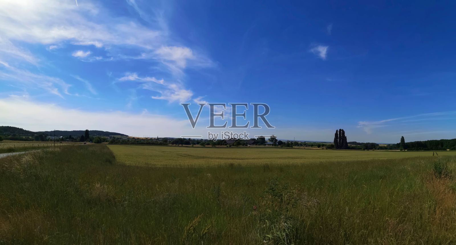 碧蓝的天空下，绿草如茵的风景照片摄影图片