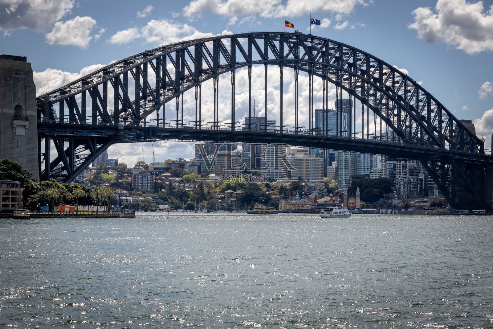澳大利亚悉尼的海港大桥在一条河上的特写，背景是摩天大楼照片摄影图片