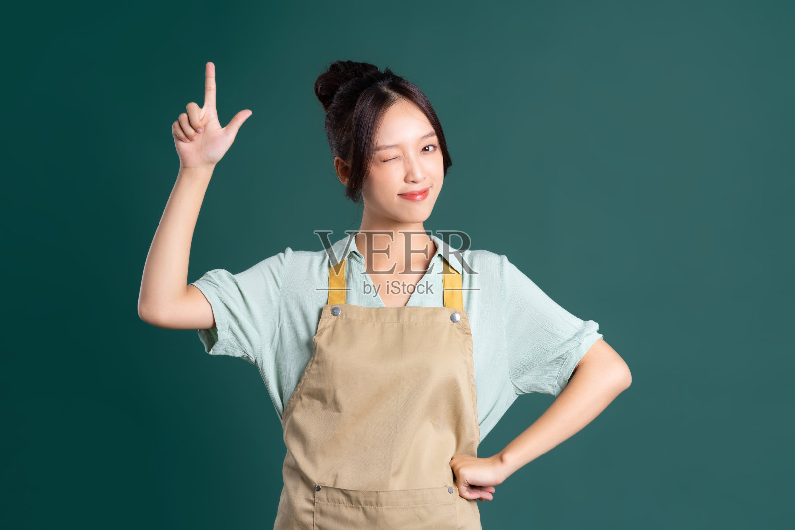 肖像的亚洲妇女穿着围裙在绿色的背景照片摄影图片