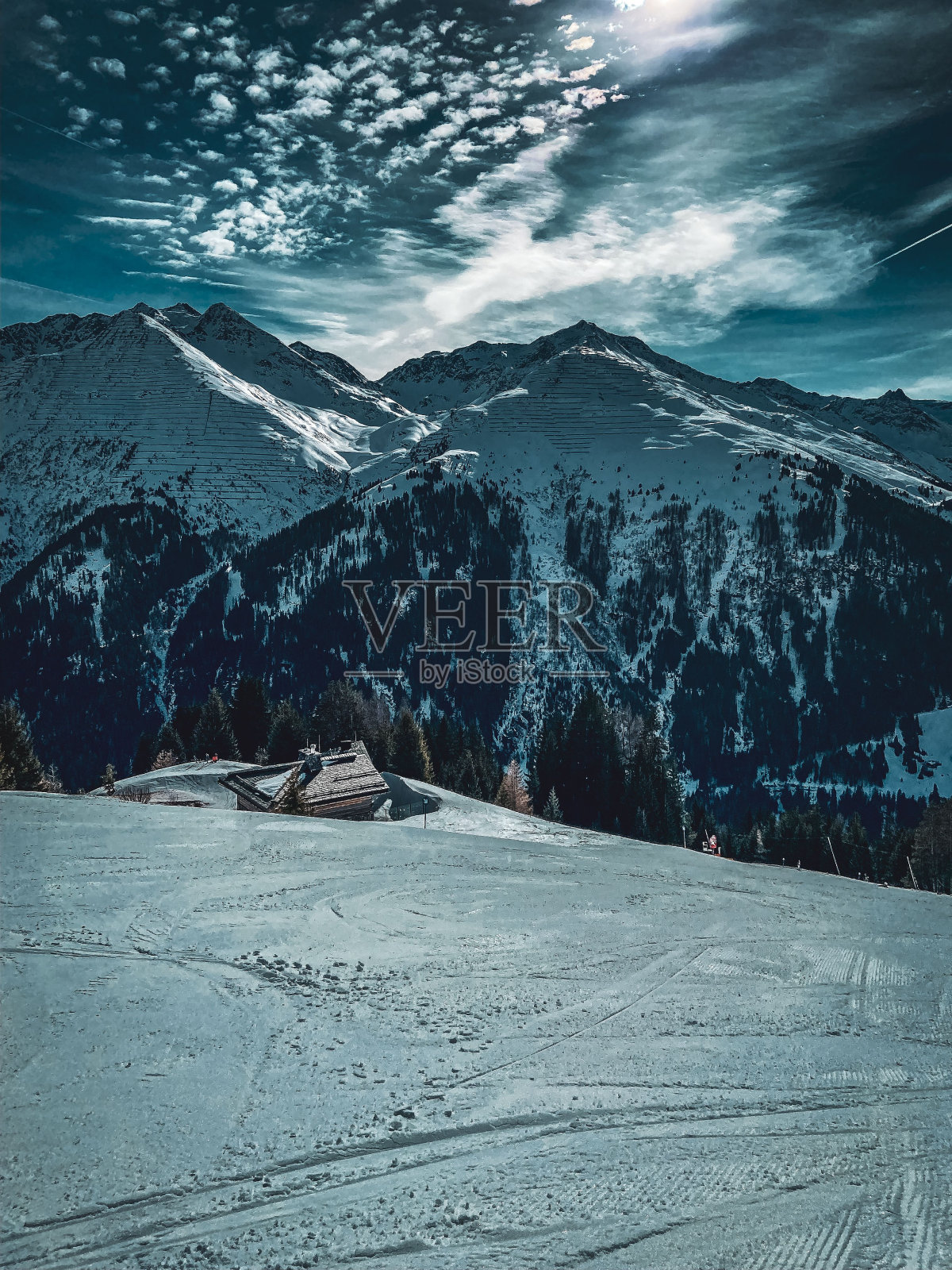 山脊状的雪山和山谷在阳光下多云的天空下呈垂直的高角度照片摄影图片