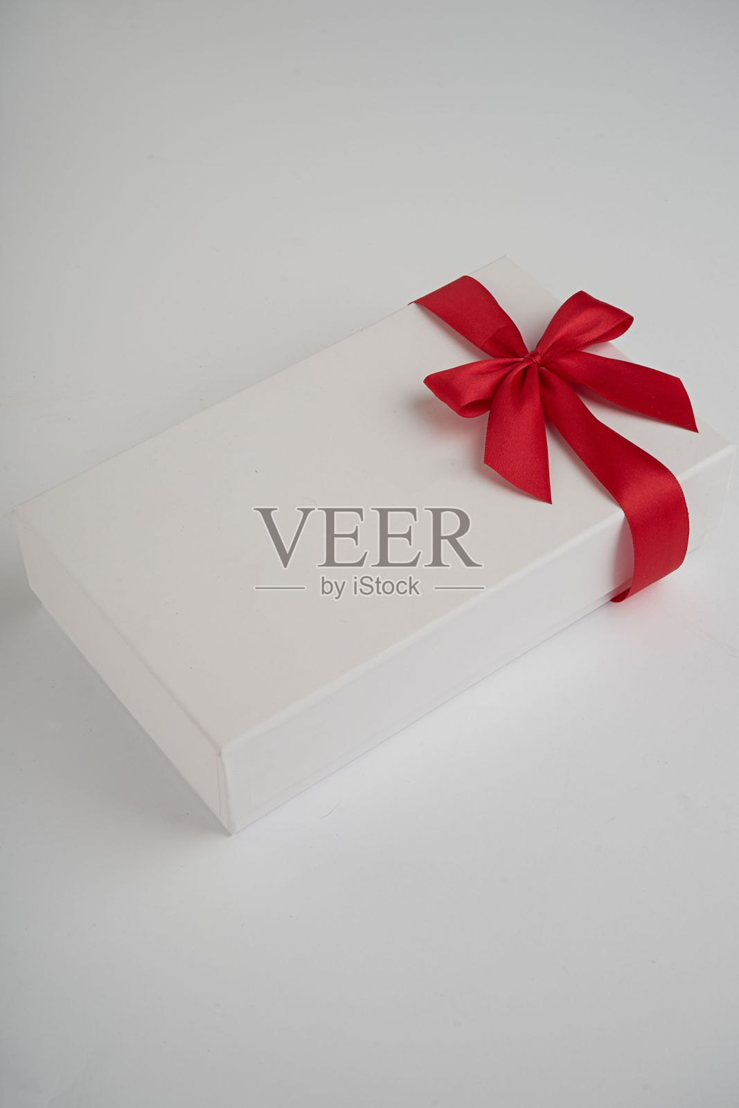 白色背景上有红丝带的白色盒子照片摄影图片