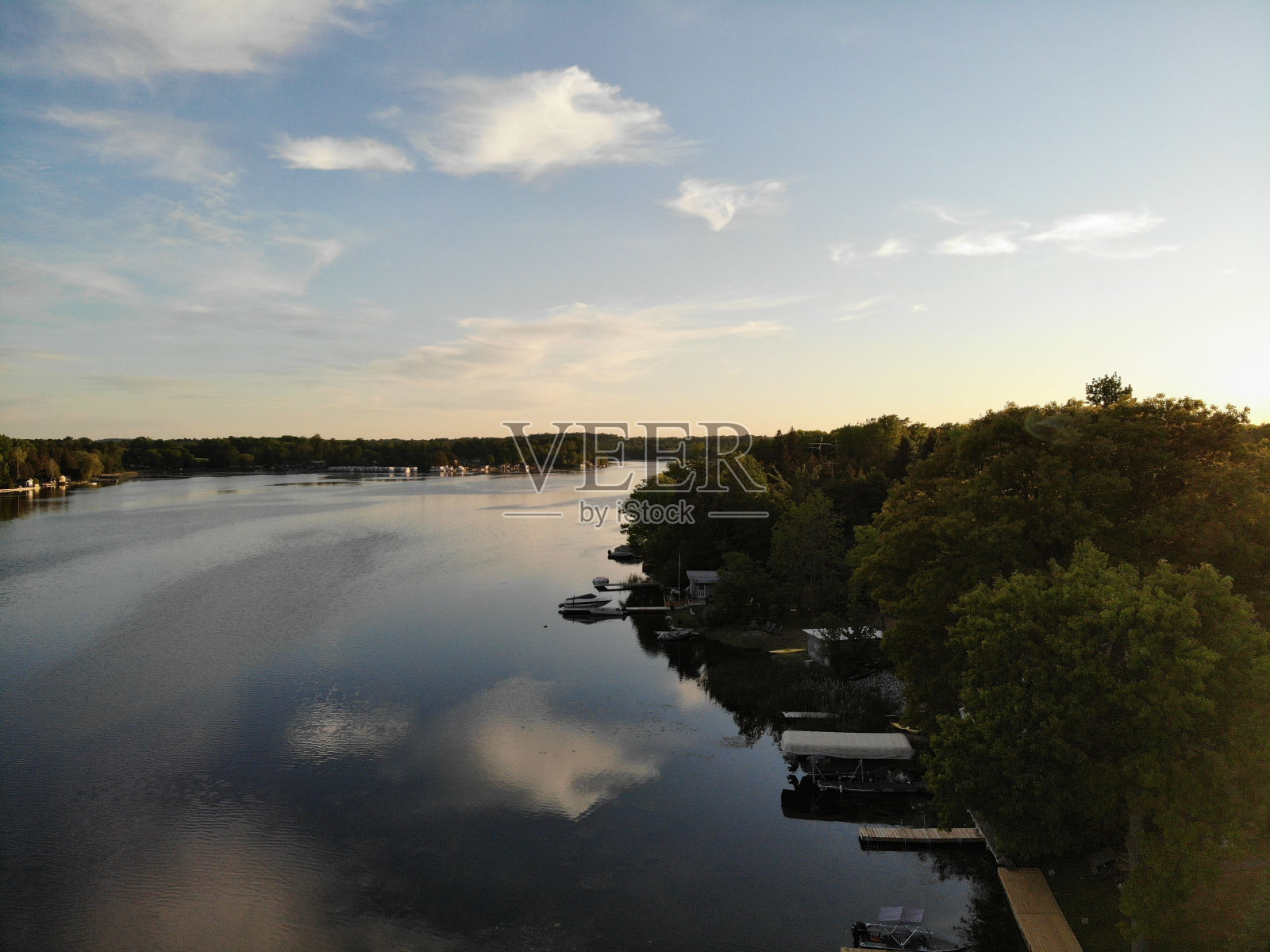 俯瞰湖岸线的木制码头，周围是绿色的森林树木照片摄影图片