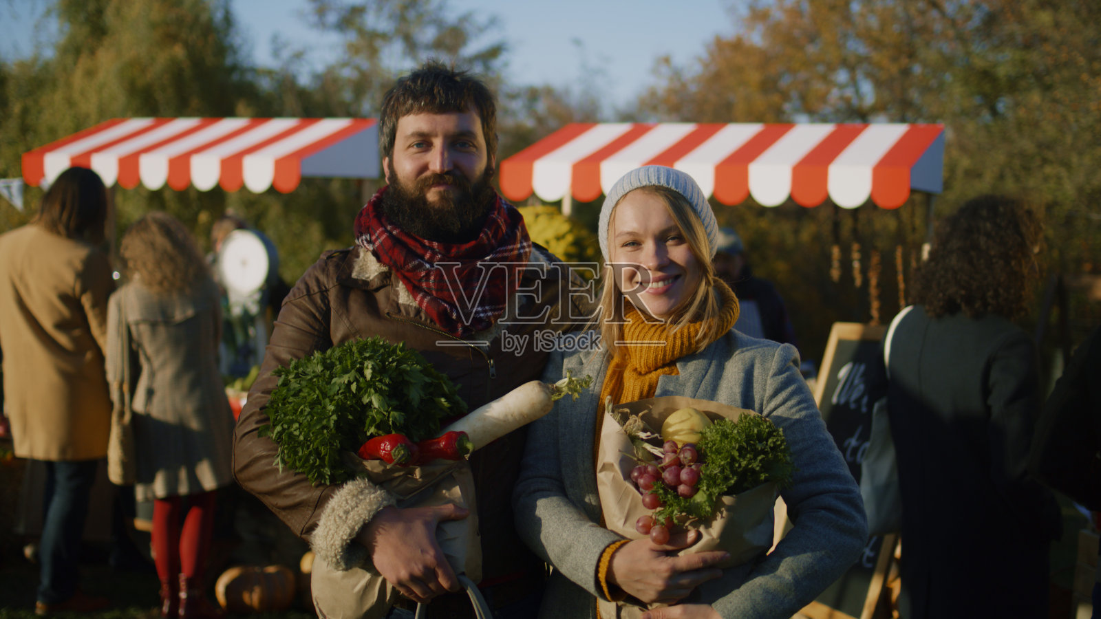 夫妻俩拿着一袋水果摆姿势照片摄影图片