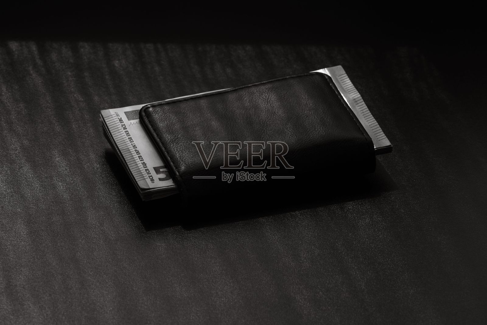 桌子上钱包里一堆欧元钞票的灰度镜头照片摄影图片