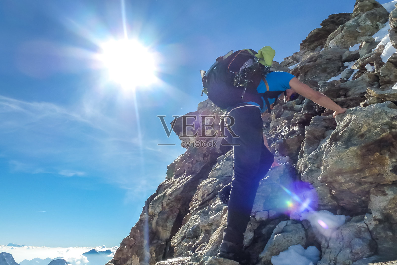 Mountaineer climbing on steep rocky terrain on Jungfrau. Jungfrau-Höhenweg, Bernese Alps, Switzerland, Europe.照片摄影图片