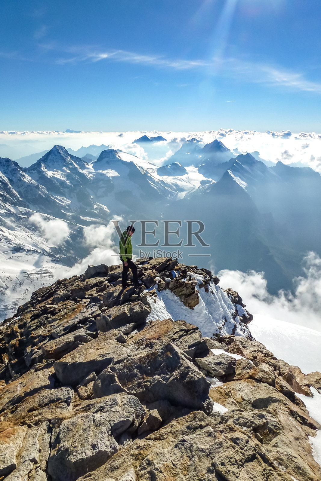 Enthusiastic mountaineer hiking on Jungfrau summit with  panoramic mountain view the background. Jungfrau-Höhenweg, Bernese Alps, Switzerland, Europe.照片摄影图片