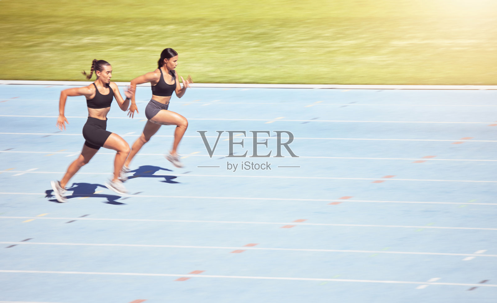 在体育运动中，短跑女运动员在体育场比赛，用镜头耀斑的力量，速度和动力。专业运动员健身人马拉松跑步，训练为目标，挑战和能量照片摄影图片