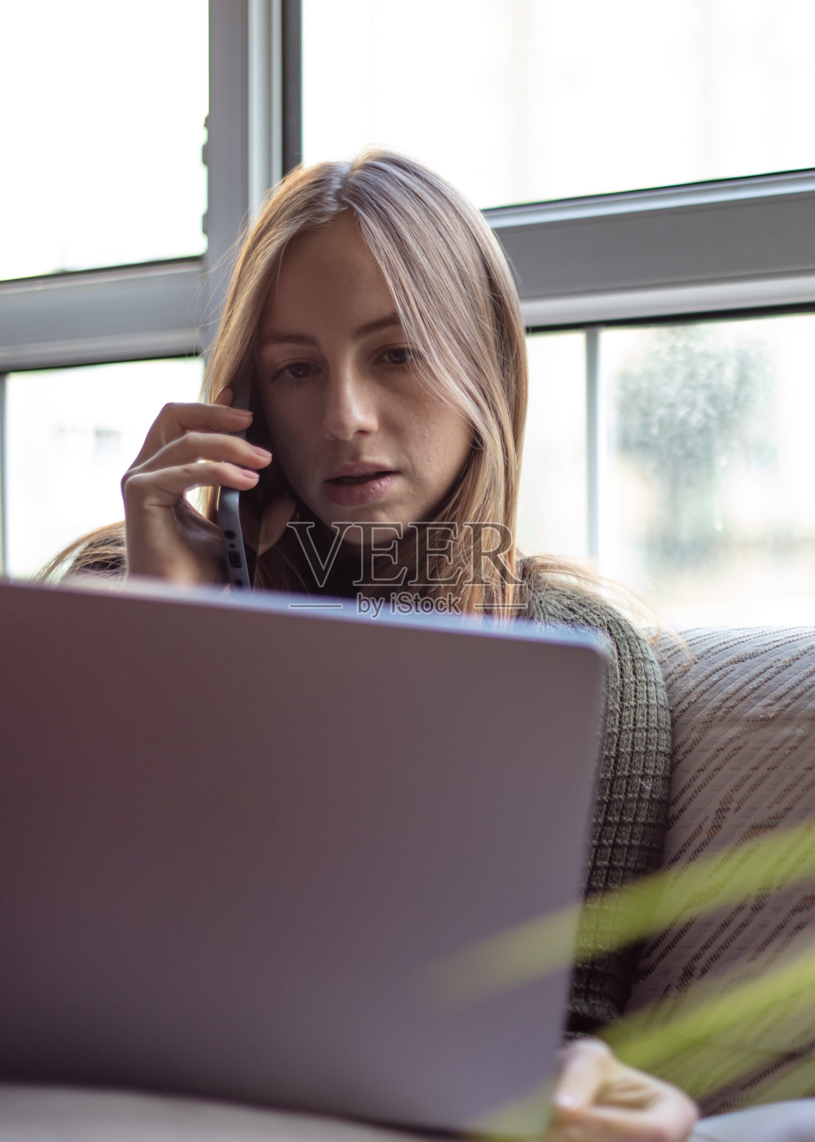 金发女人在家里工作。照片摄影图片