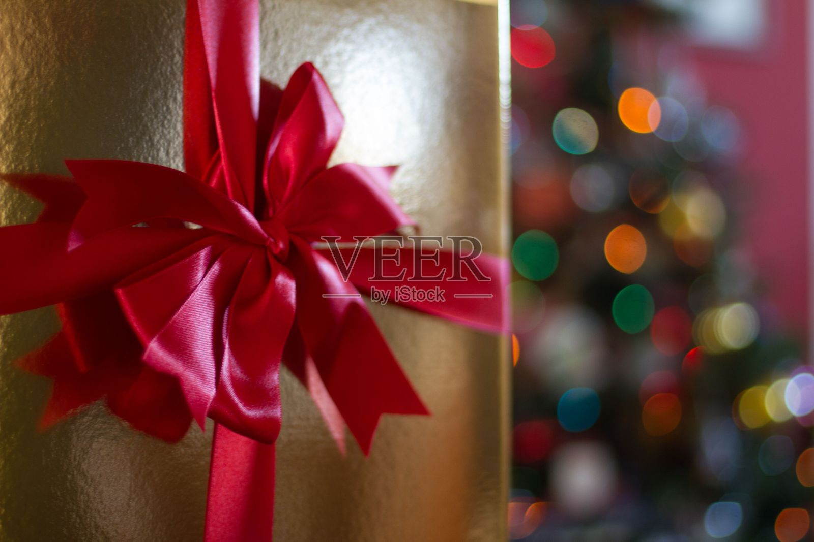 特写的黄金礼盒与红色的丝带圣诞节与模糊的背景照片摄影图片