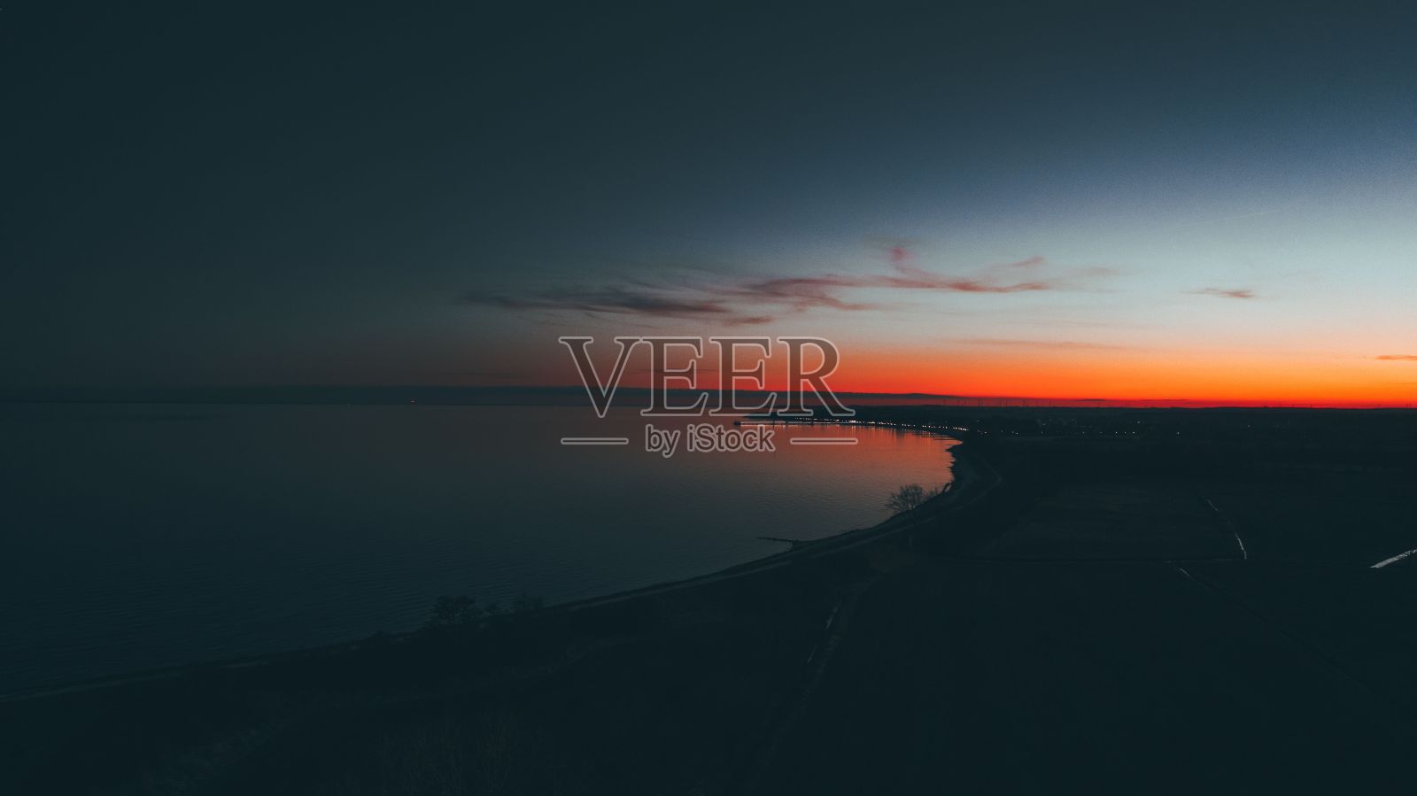 明亮的发光橙蓝色日落天空的水照片摄影图片