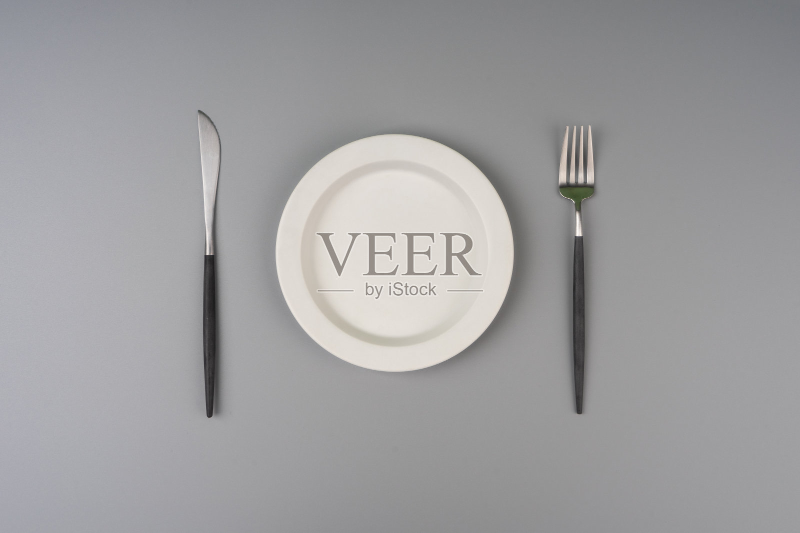 盘子，叉子和刀在灰色背景上照片摄影图片