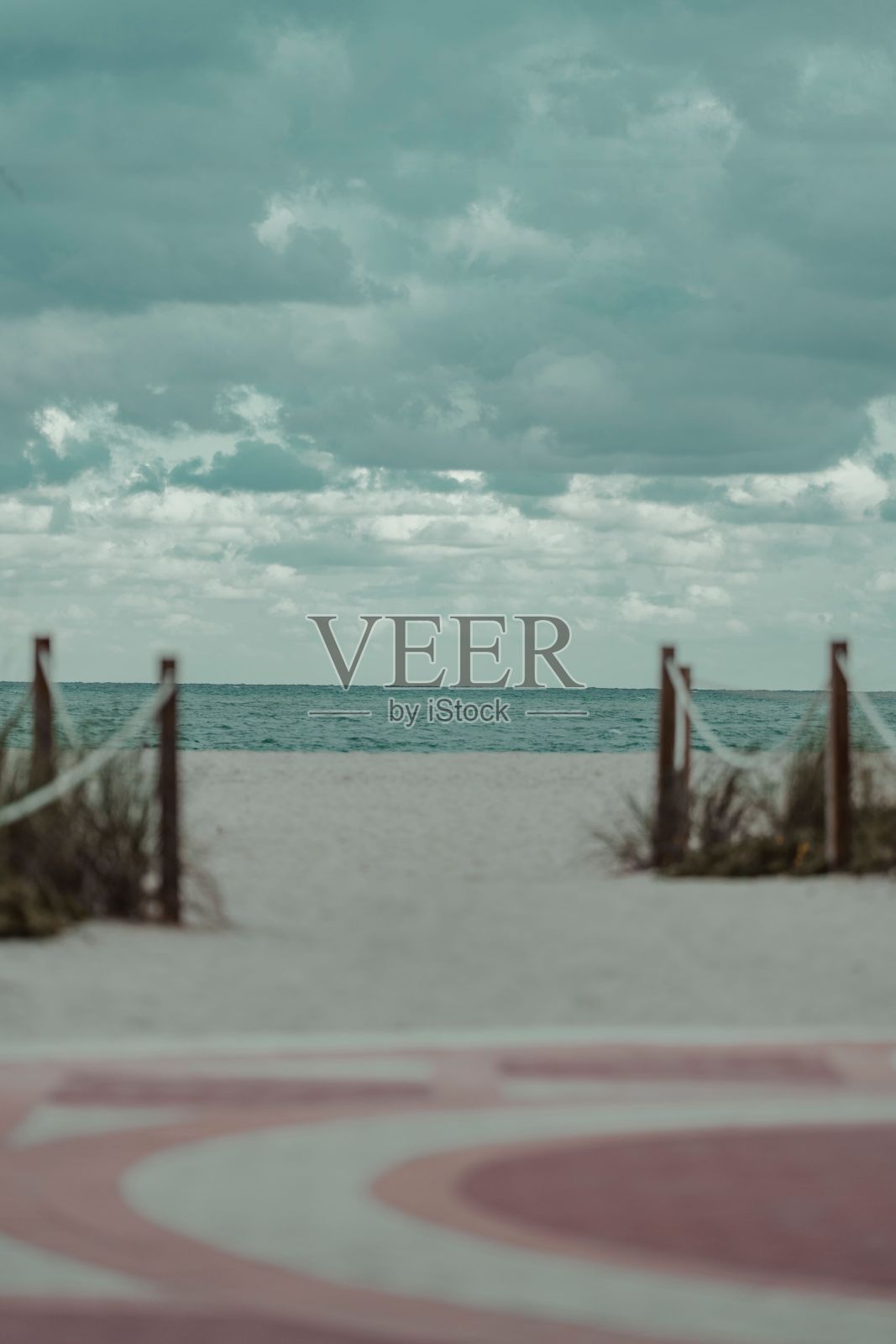 沙滩上有低矮的木门，通向云雾缭绕的大海照片摄影图片