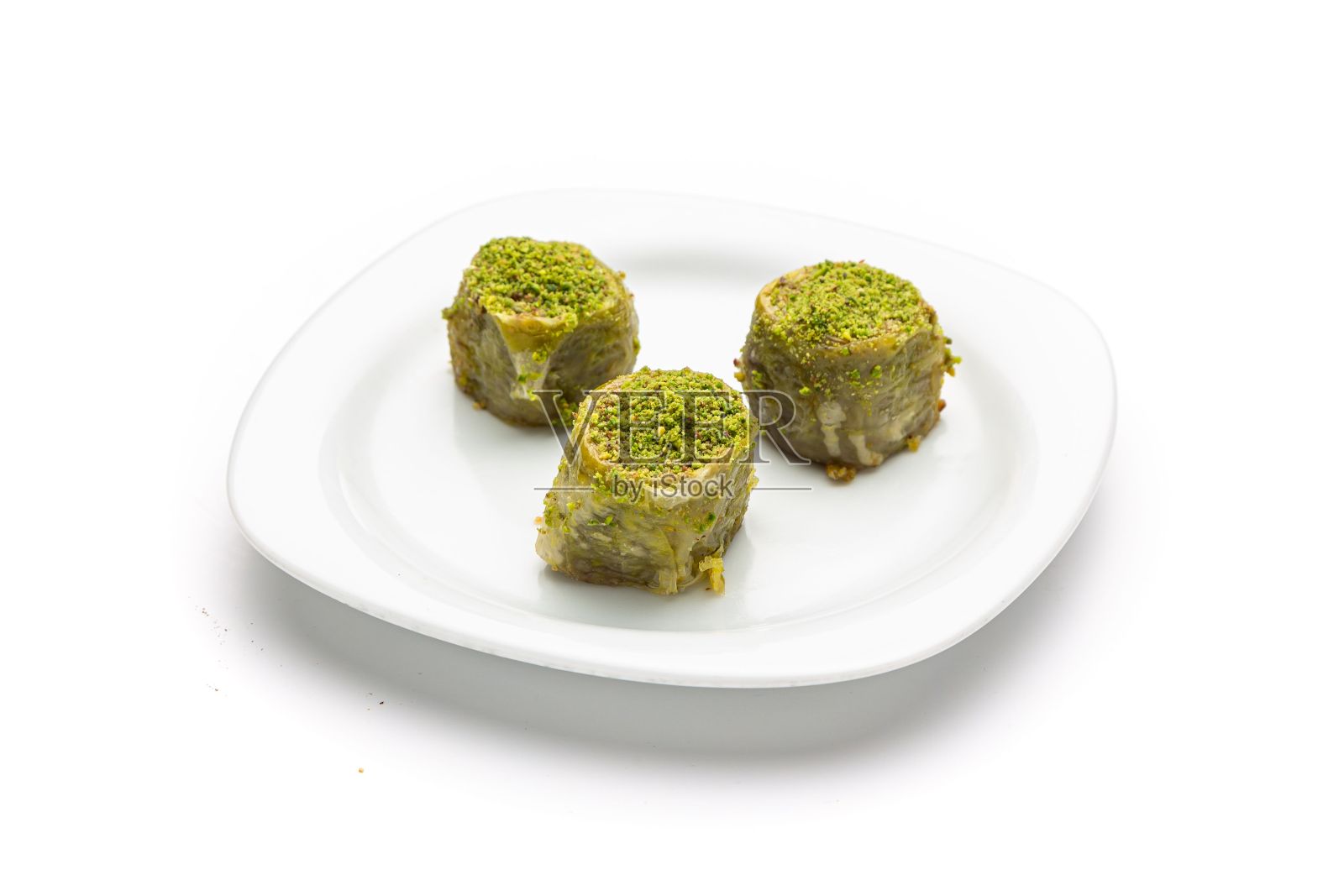 绿色果仁蜜饼放在白色背景的盘子里照片摄影图片