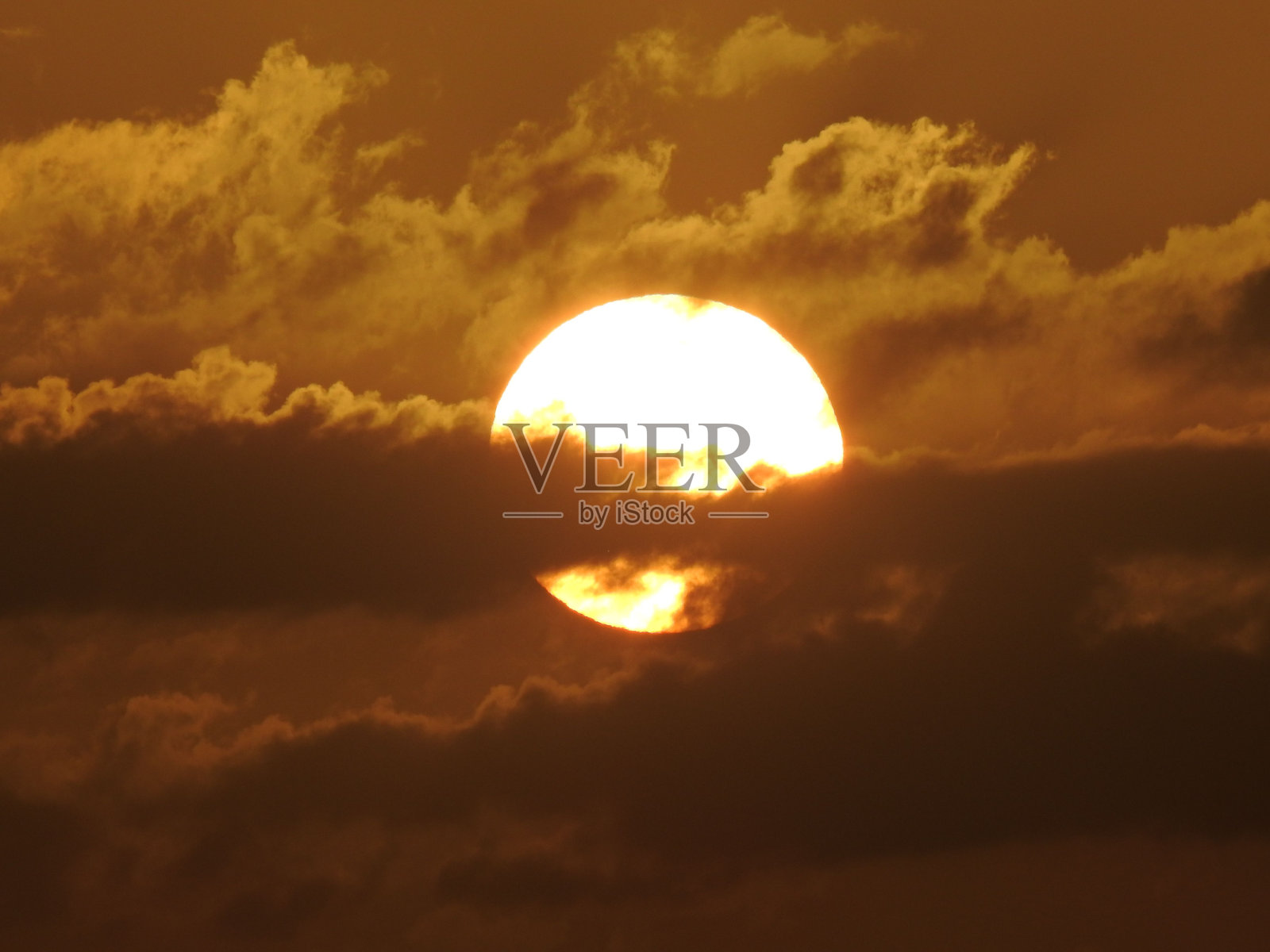 密集云层后面燃烧的圆形太阳特写照片摄影图片