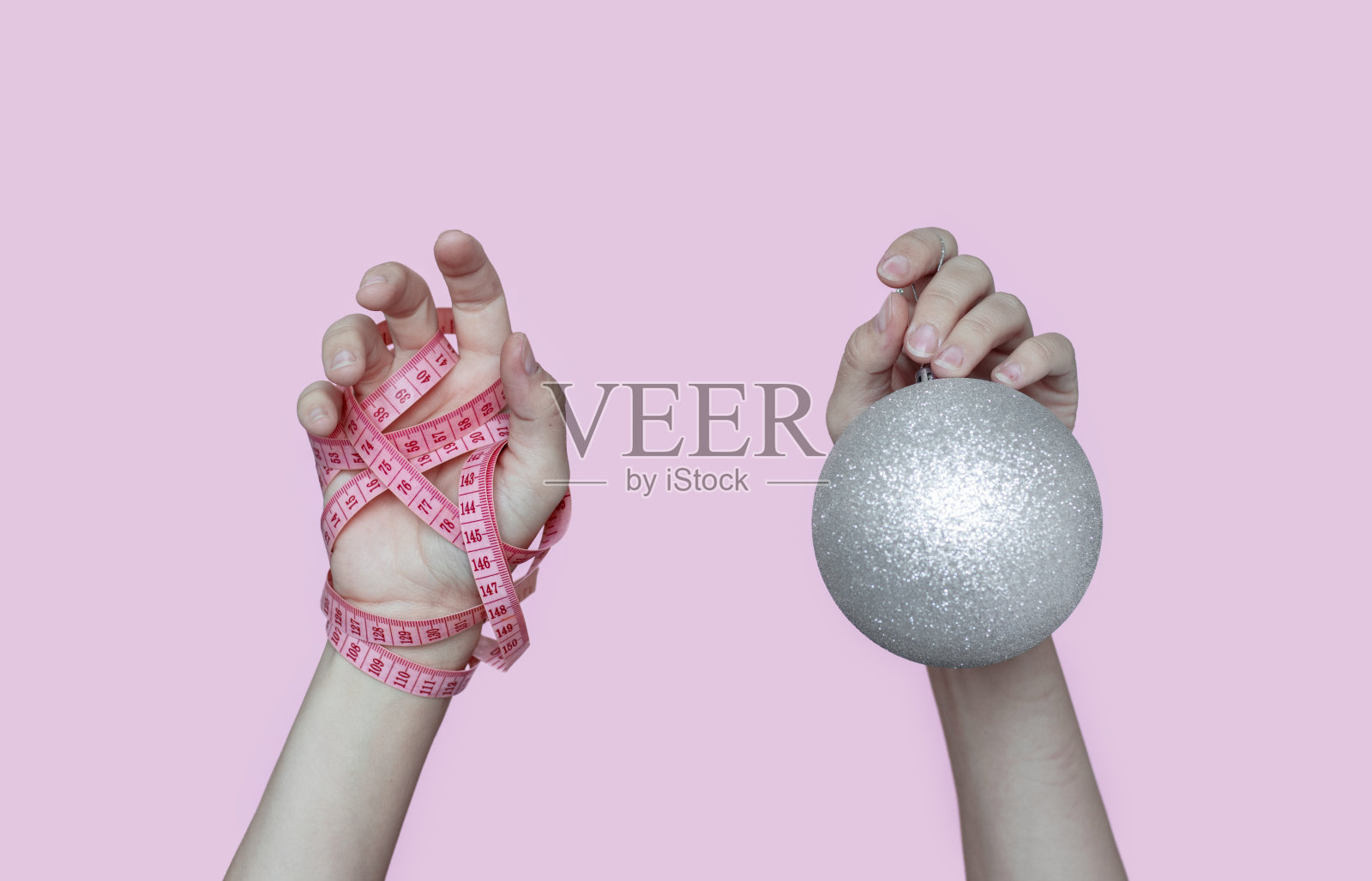 产后减重产后恢复肚腩。年轻的母亲肩上扛着卷尺，手里拿着黄色的苹果或盘子里放着不同的药片，用叉子分开吃。照片摄影图片