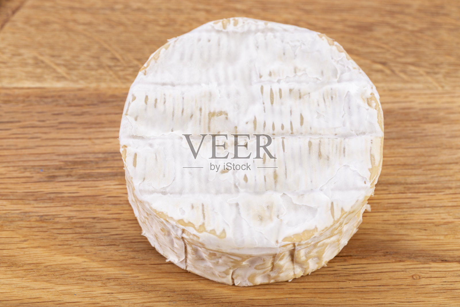 布里干酪。卡蒙贝尔奶酪放在木桌上。新鲜布里奶酪。法国奶酪。照片摄影图片