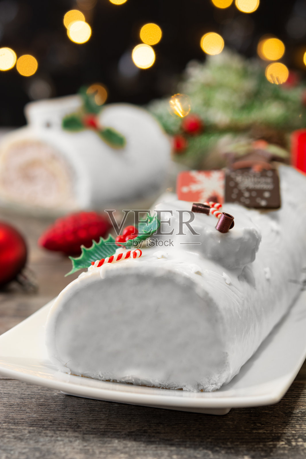 白巧克力圣诞原木蛋糕与圣诞彩灯照片摄影图片