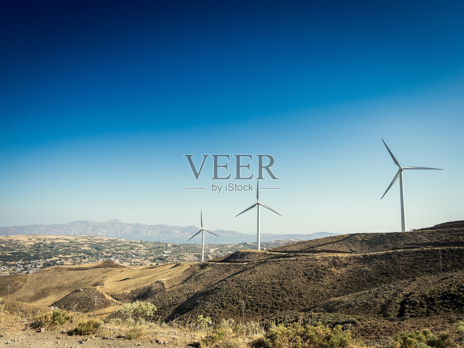 山上的风力发电机映衬着蓝天照片摄影图片