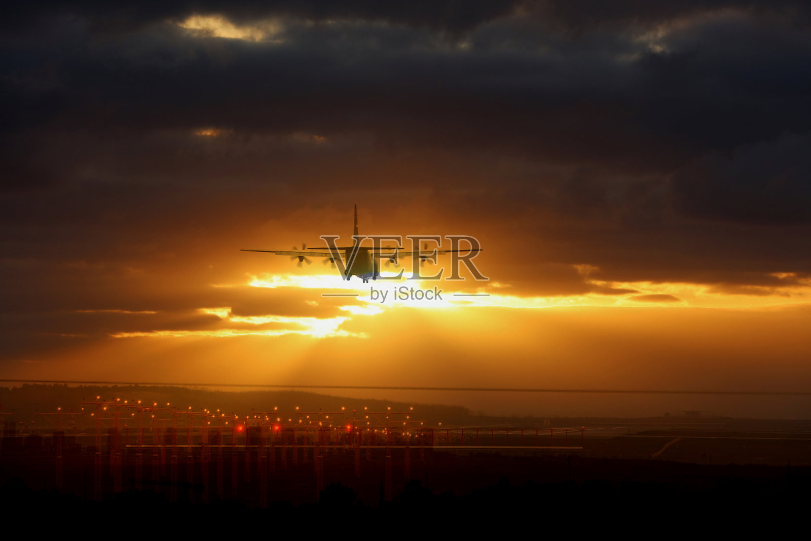 飞机在日落时降落在机场照片摄影图片