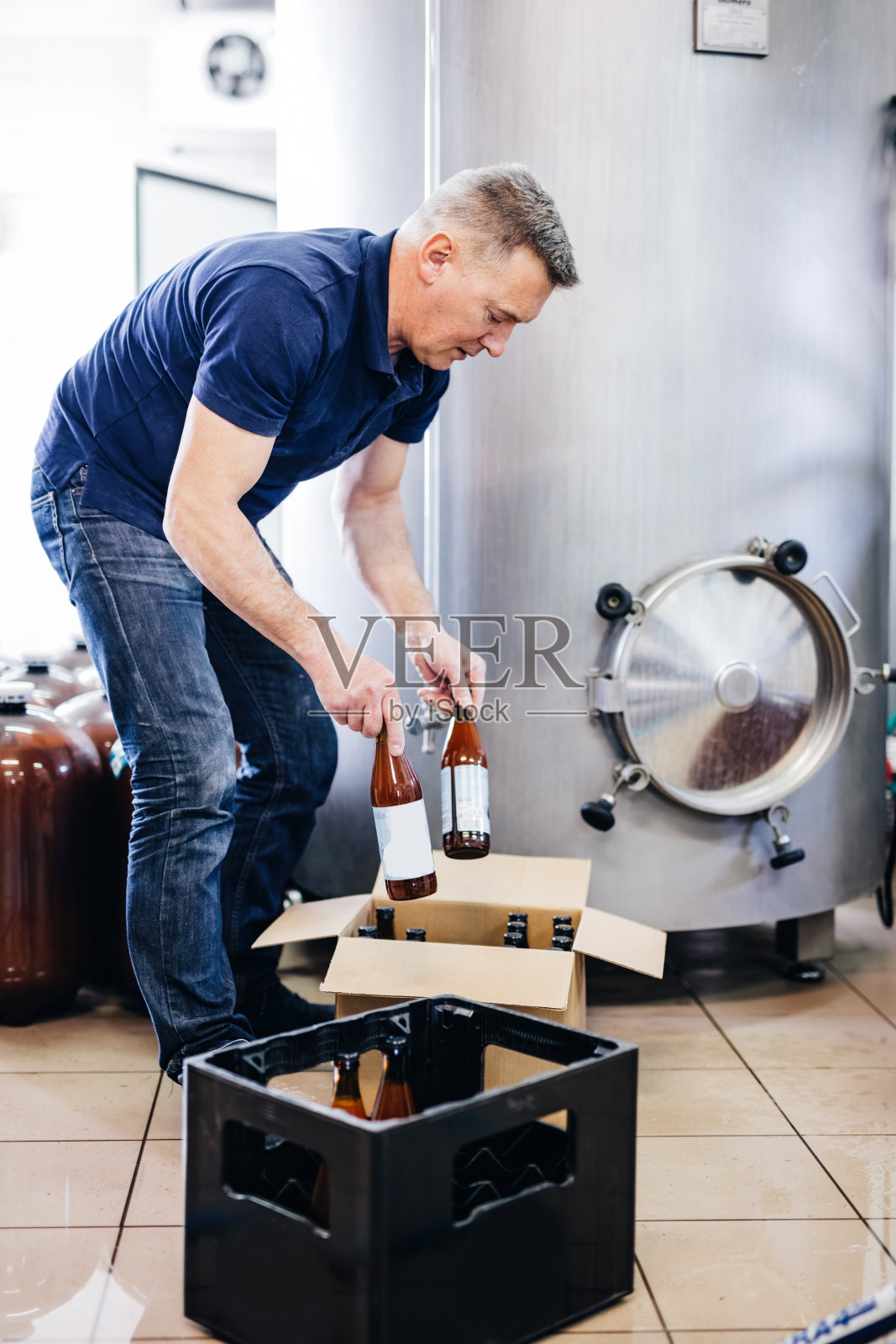 男子准备从啤酒厂精酿啤酒装运。照片摄影图片
