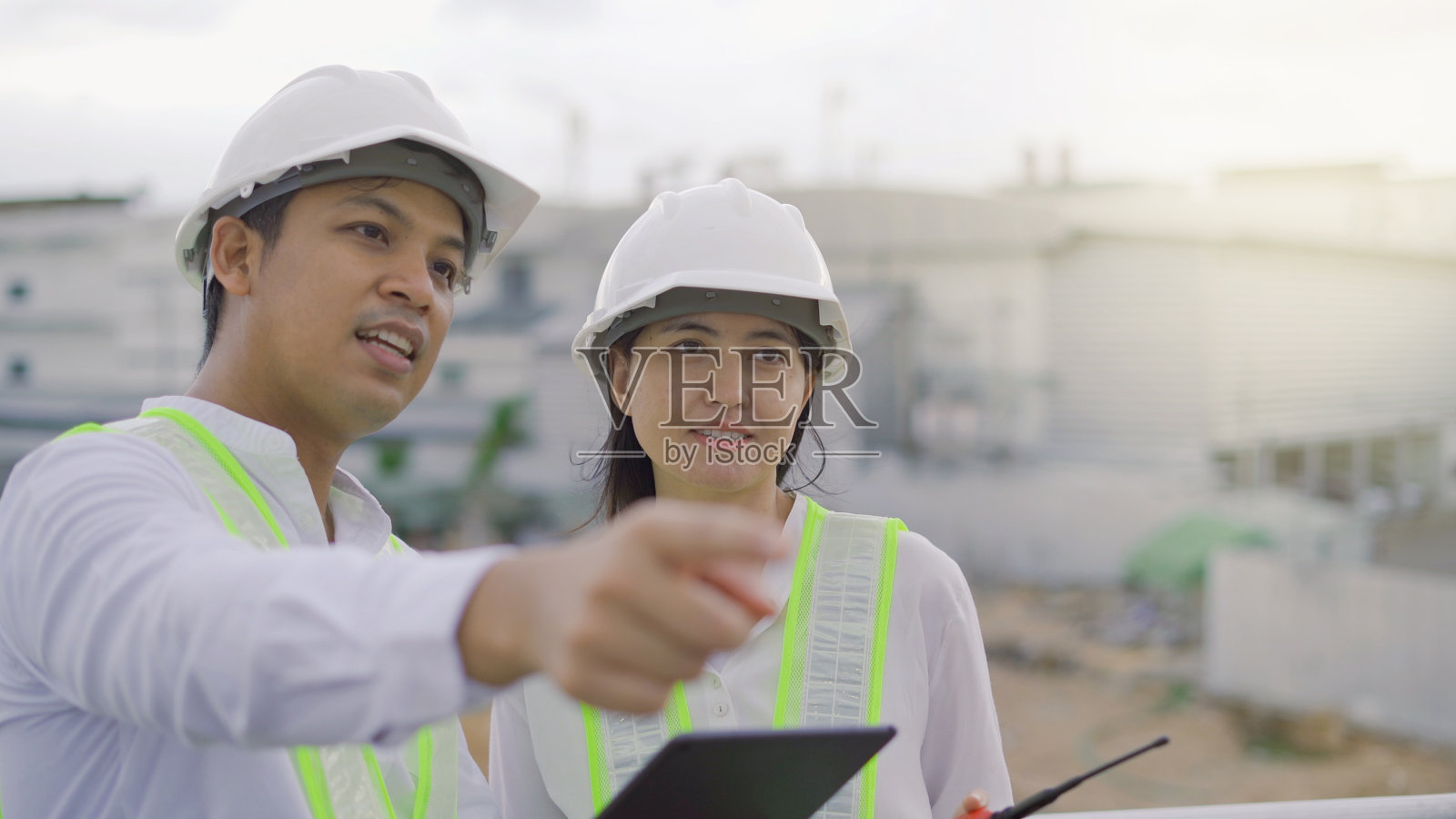 两名土木工程师在施工现场检查建筑师图纸。照片摄影图片