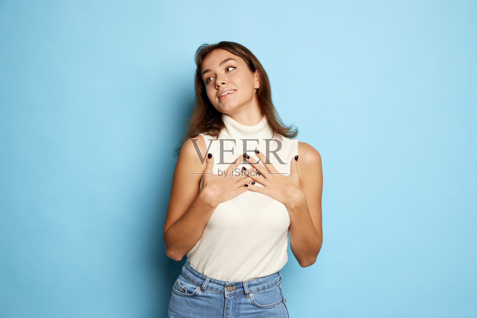 年轻美丽的女人的肖像与愉快的表情孤立在蓝色的工作室背景照片摄影图片