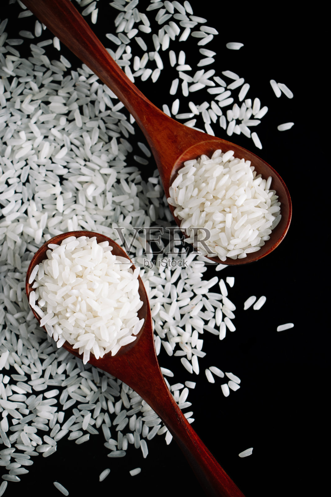 白色的生米放在木勺里，黑色的背景。天然有机素食。照片摄影图片