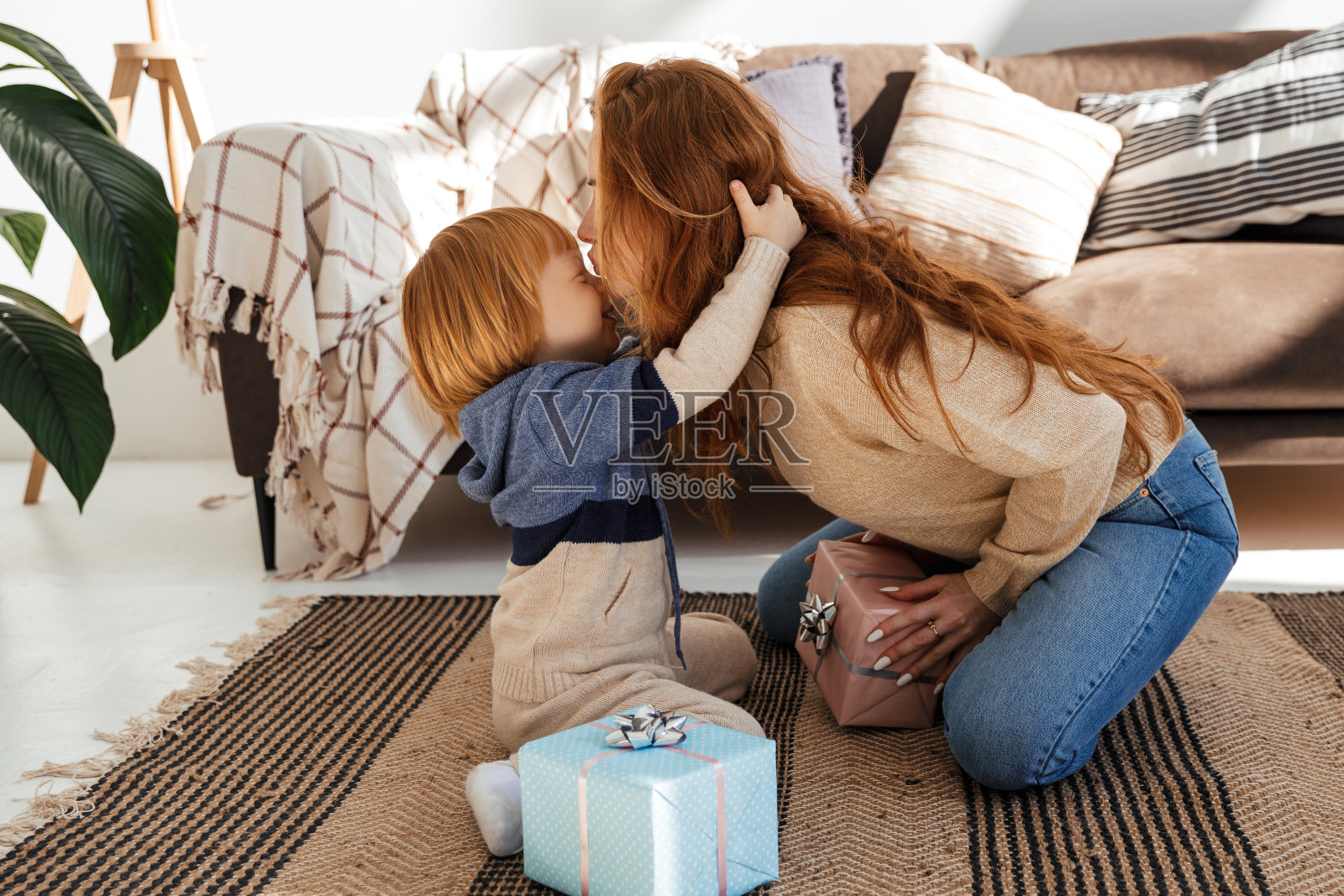 可爱的红头发小男孩送给妈妈一份圣诞礼物照片摄影图片