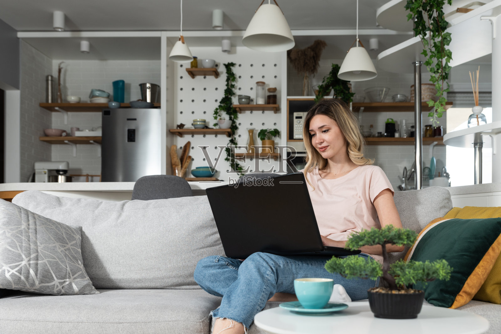 年轻的商业女性家庭室内设计师在她的笔记本电脑上为新客户买了公寓。女风水专家看着她用电脑设计的家具。照片摄影图片