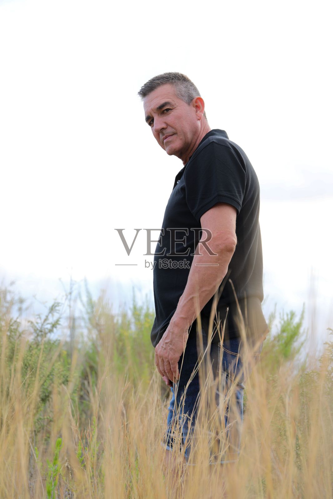 一个白人成年男子在田野里的垂直镜头照片摄影图片