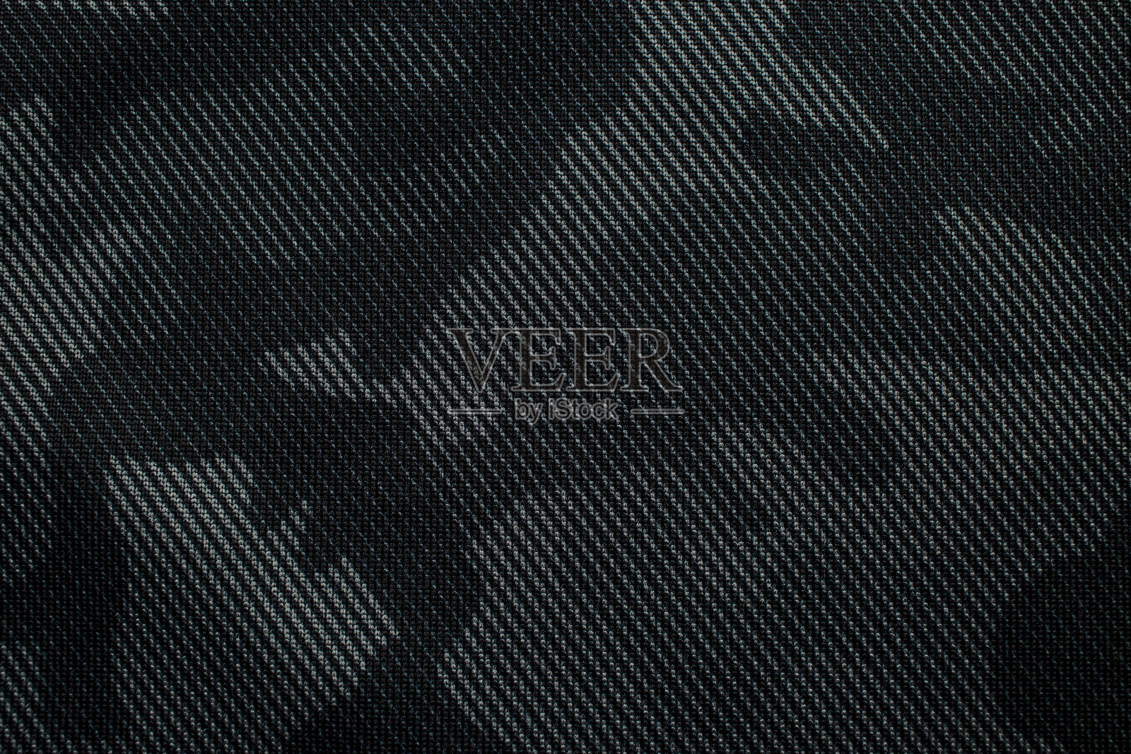 迷彩图案。时髦的深灰色迷彩面料。军事上的纹理。黑暗的背景。照片摄影图片