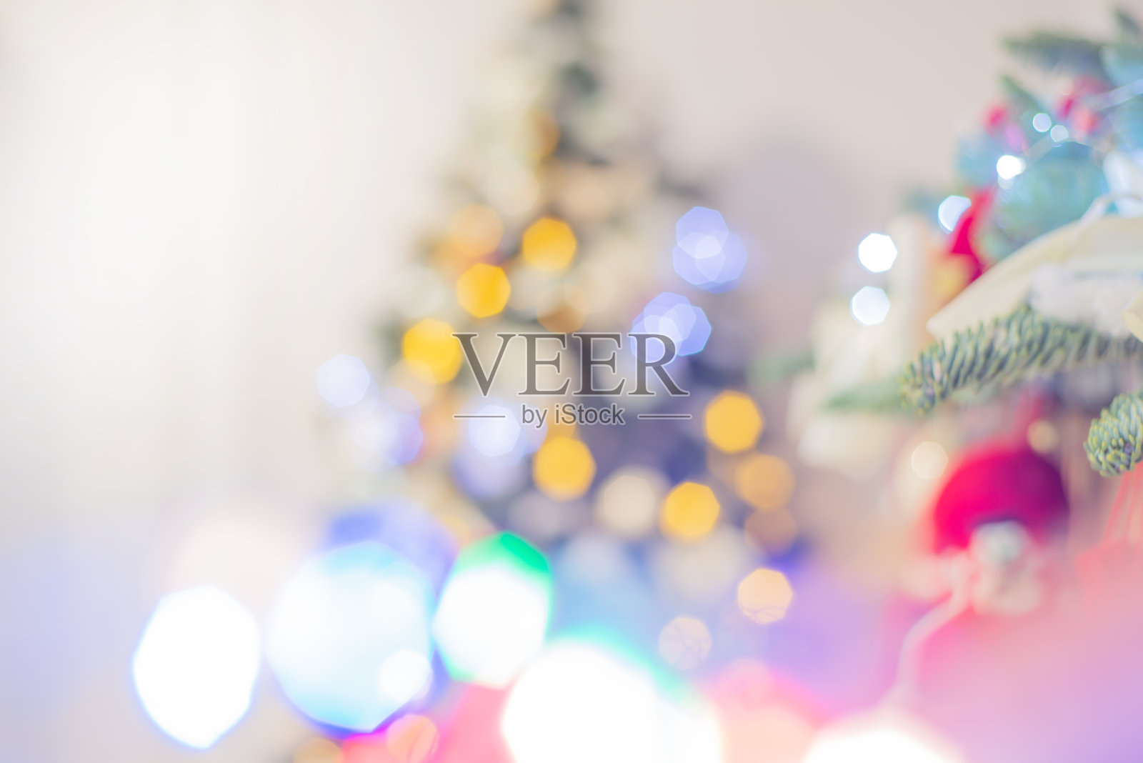 失焦模糊的灯光和散景的一个装饰圣诞树的灯光剪影在浅色。节日的背景照片摄影图片