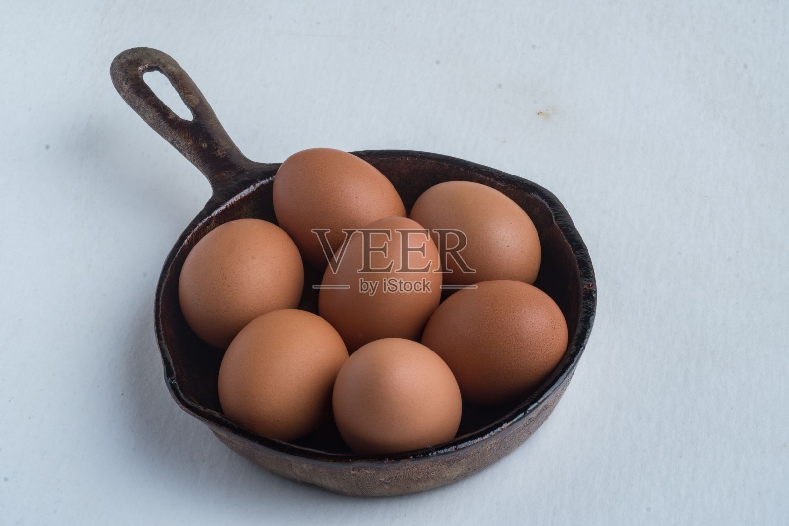 白底黑锅里鸡蛋的特写镜头照片摄影图片