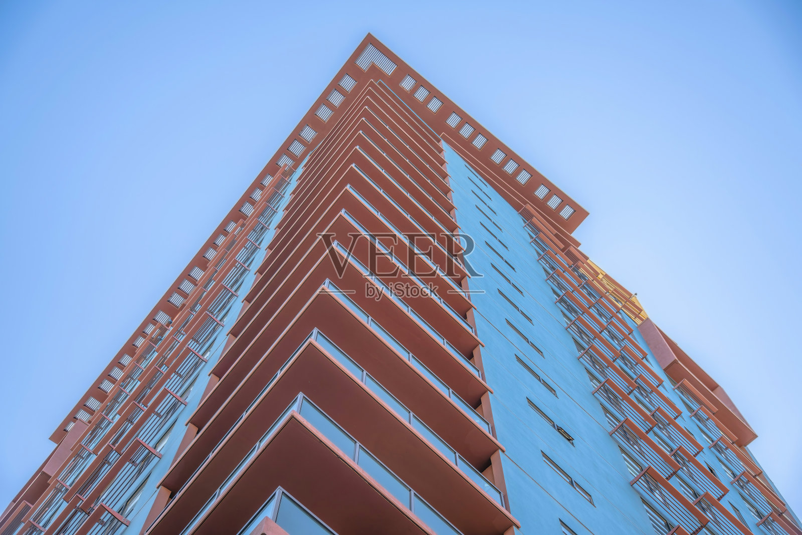 凤凰城，亚利桑那州-在低角度视野的角落阳台上有玻璃栏杆的建筑照片摄影图片