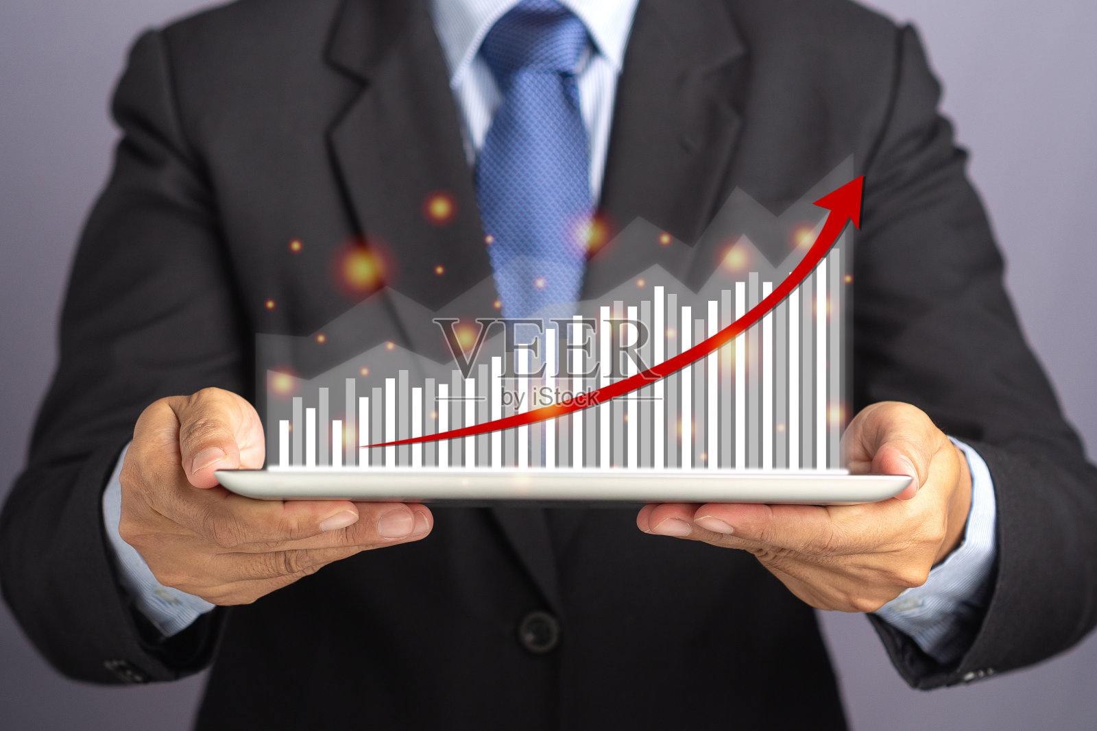 商人手握平板电脑和显示图表的统计与箭头向上照片摄影图片