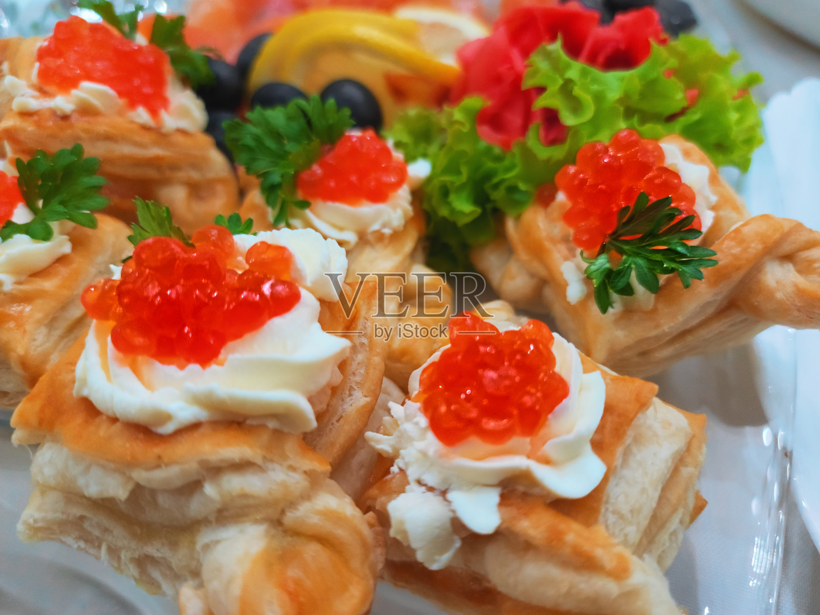 满盘子的红鱼子酱吐司配奶油芝士和欧芹照片摄影图片