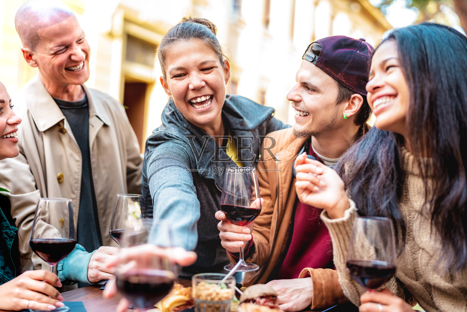 快乐的朋友在城市酒庄酒吧畅饮红酒-年轻人在露天餐厅花园共度冬日-从个人角度出发的青春生活理念照片摄影图片