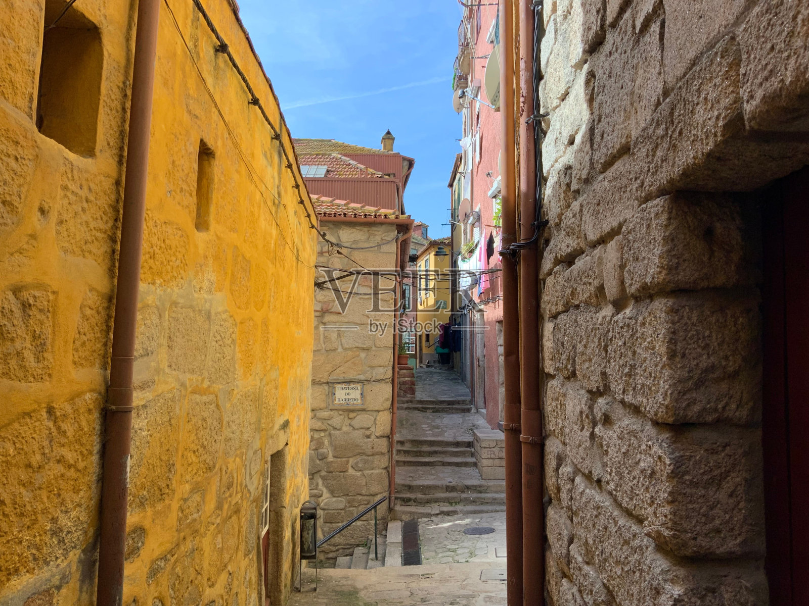 在晴朗的天空下，旧建筑之间的狭窄空间特写镜头照片摄影图片