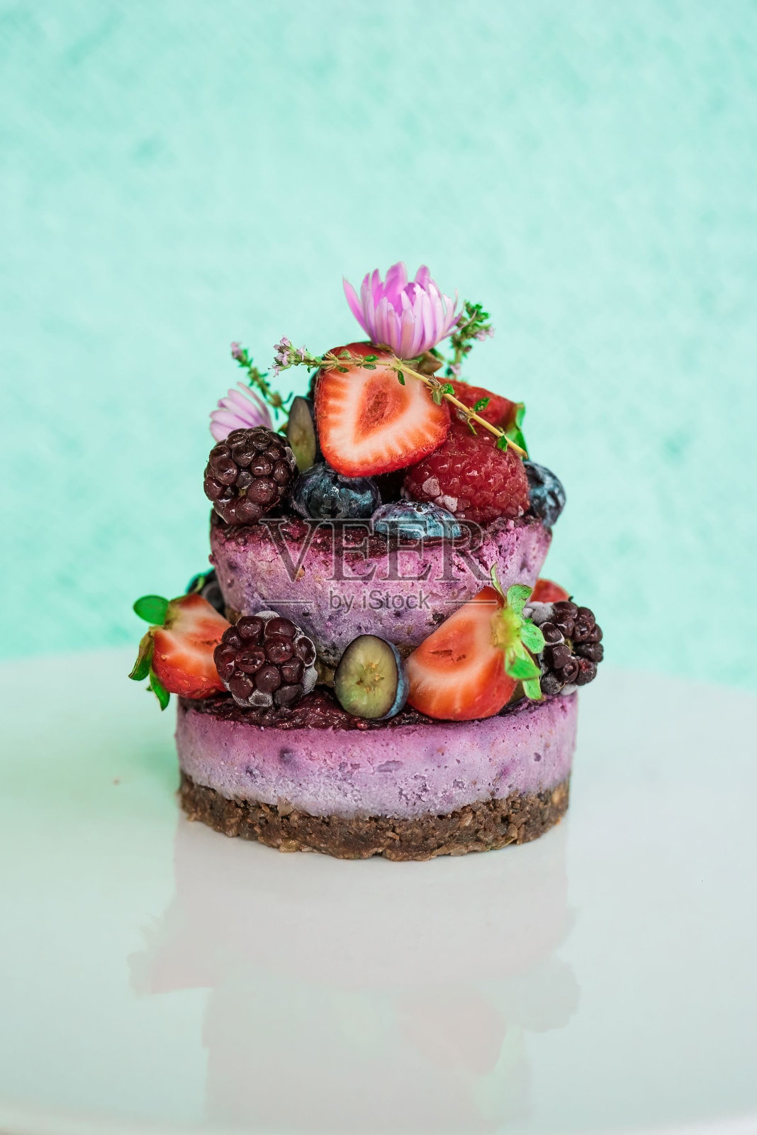 垂直特写的小蛋糕，草莓，巴西莓，覆盆子和野花。照片摄影图片