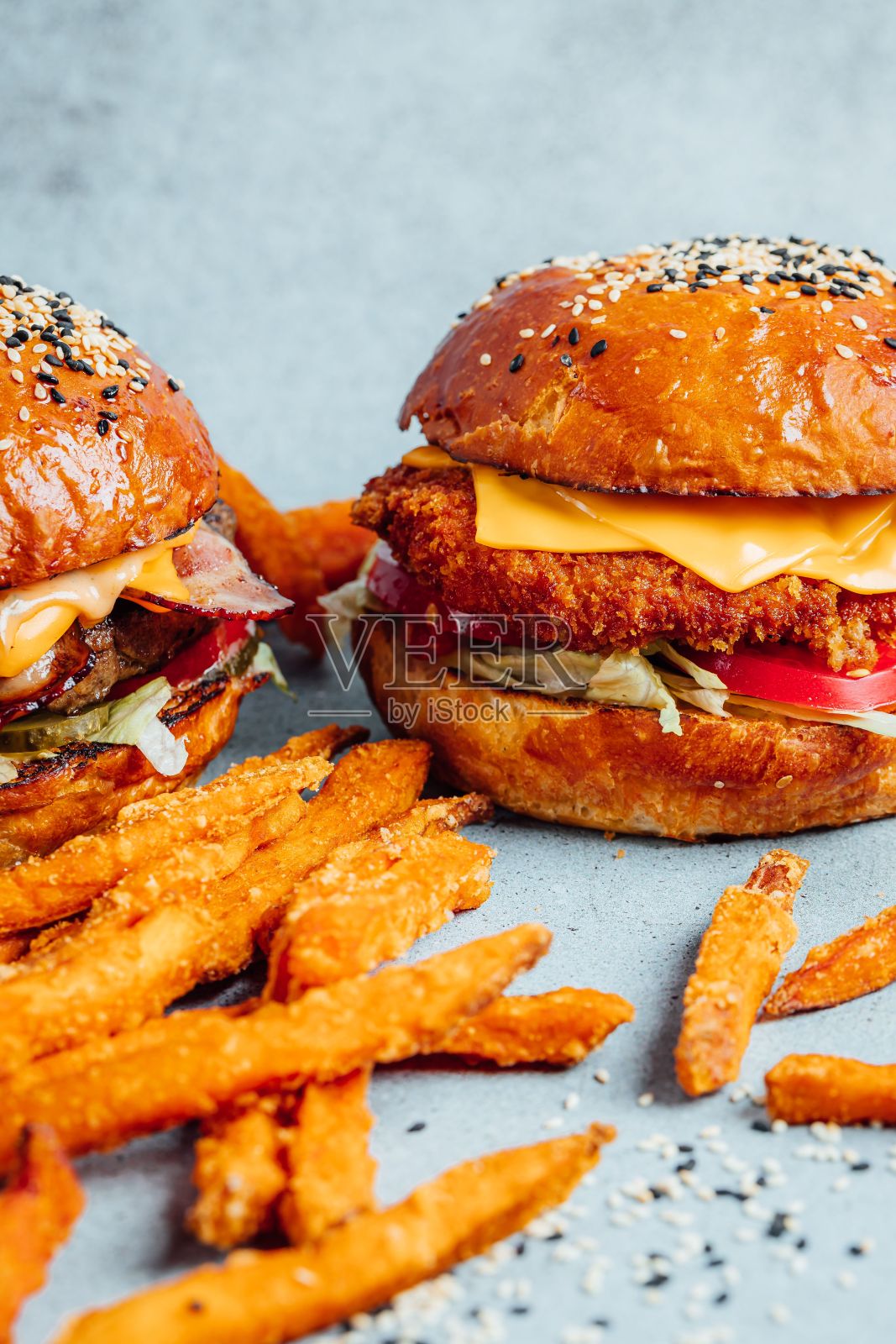 垂直拍摄的经典汉堡在明亮的背景与薯条照片摄影图片