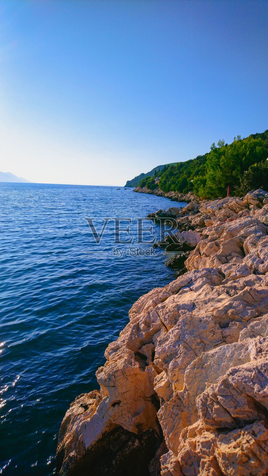 垂直拍摄美丽的蓝色大海冲刷岩石海岸照片摄影图片