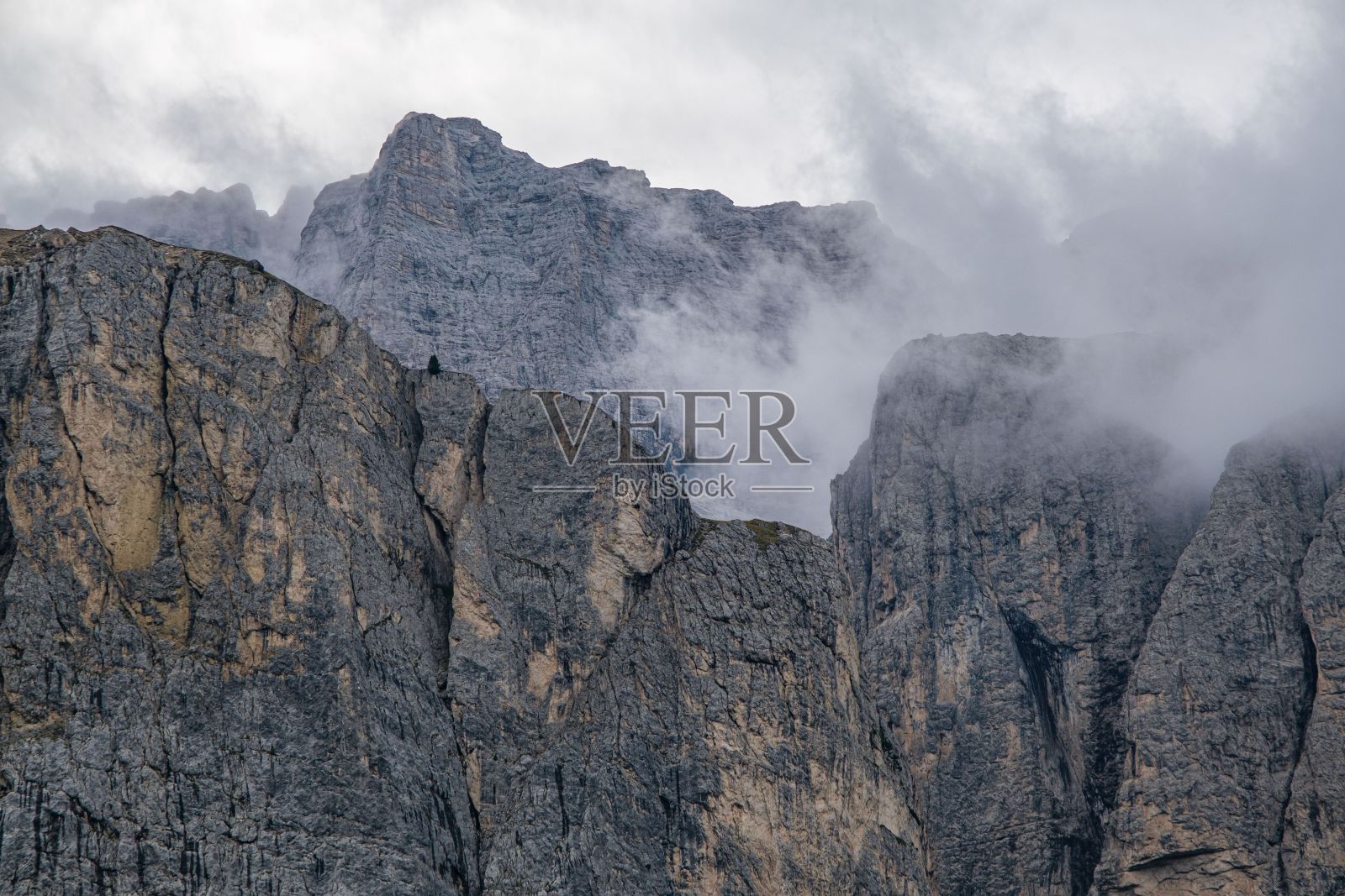 在意大利南蒂罗尔阿尔卑斯山脉的白云石上，云层笼罩着一块岩石照片摄影图片