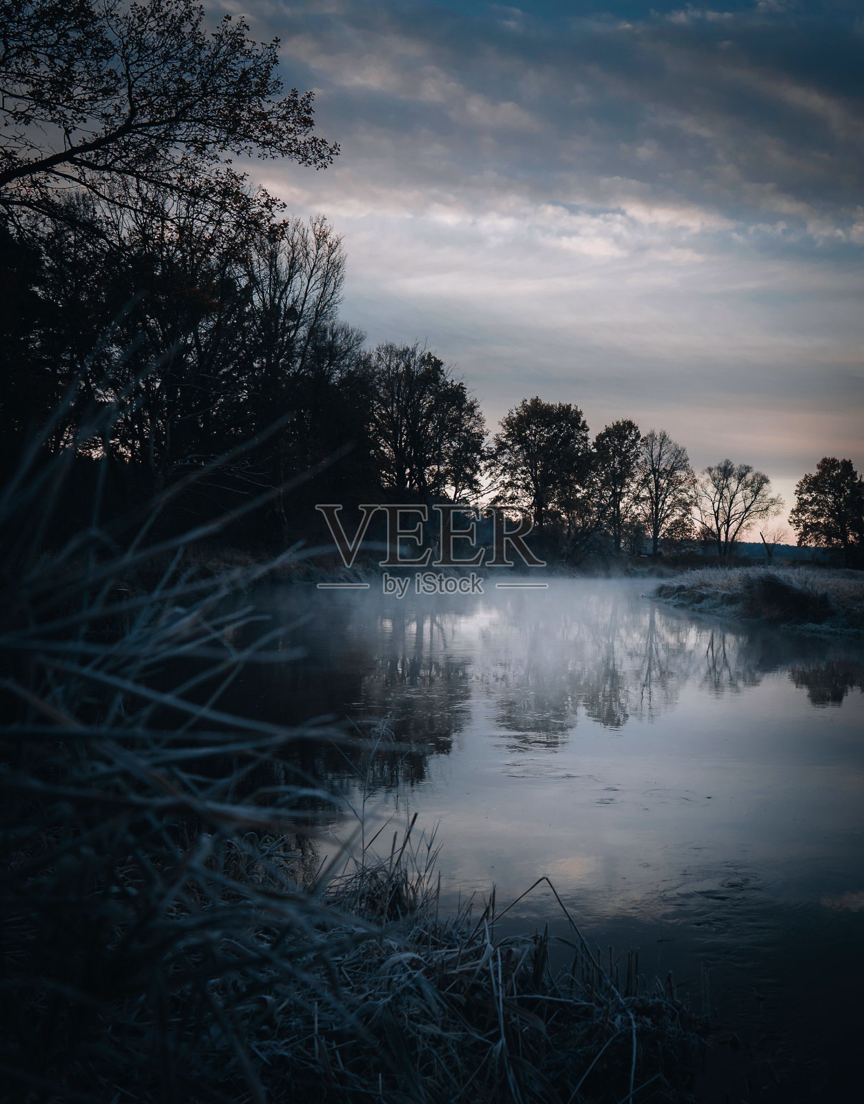 垂直拍摄的日出天空反射在树木环绕的湖面上照片摄影图片